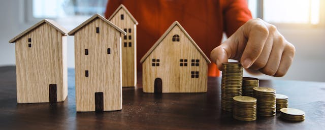 a bunch of house figurines with coins next to them