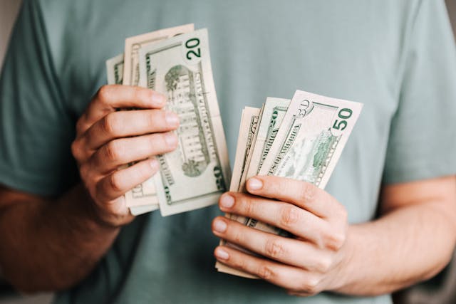 a person in a green shirt counting cash