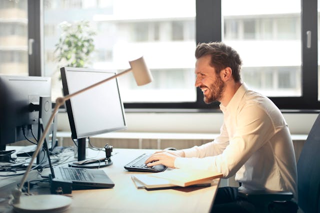 a person sitting at a desk working on their computer